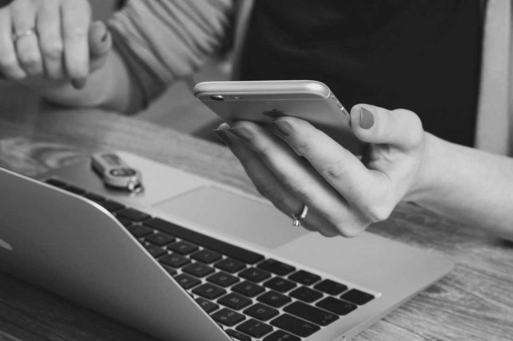 woman at her work desk with cellphone at hand